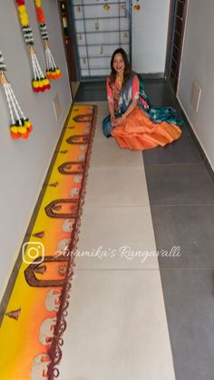 a woman is sitting on the floor in front of a decorated wall with hanging decorations