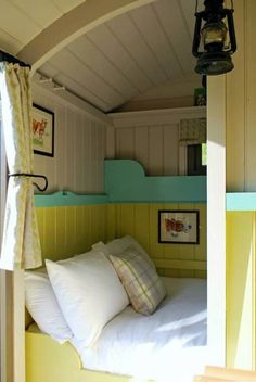 there is a bed with white sheets and pillows in the room that has yellow walls