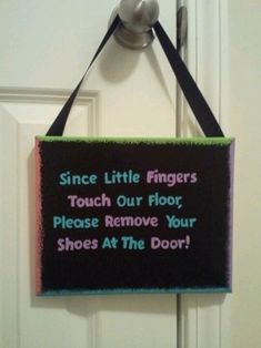 a sign hanging on the door saying, since little fingers touch our floor, please remove your shoes at the door