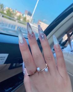 a woman's hand with long, shiny nails in the middle of her fingers