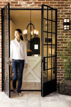 a woman standing in the doorway of a brick building