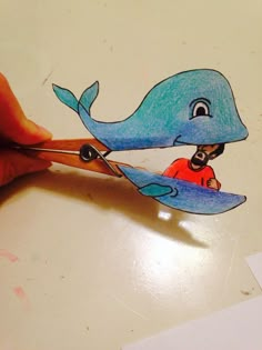 a drawing of a blue whale being cut with scissors