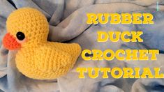 a crocheted rubber duck laying on top of a blanket with the words rubber duck crochet pattern