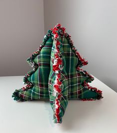 a green and red plaid christmas tree sitting on top of a white table