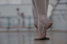 a ballerina's feet in ballet shoes on the danceflossy floor