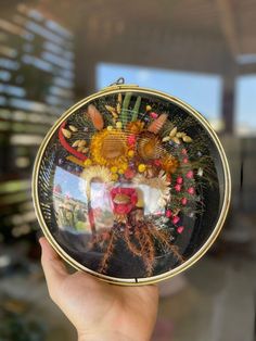 a person holding up a glass plate with pictures on it