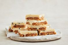 five pieces of cake sitting on top of a paper plate with white frosting and blueberries