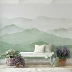 a white bench sitting in front of a wall with mountains painted on it