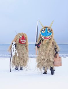 two people dressed in costumes holding surfboards on the beach