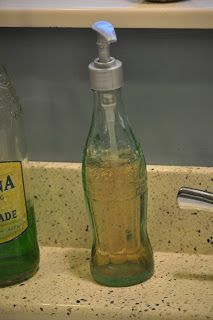 there are two bottles on the counter with soap and toothbrushes in them, one is empty