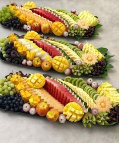 three trays filled with different types of fruit