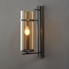 a light that is on the wall next to a gray wall with a metal frame