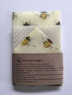 two bees on white fabric with brown paper in front of the packaging for eco wraps