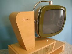 an old fashioned television sitting on top of a wooden stand