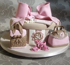 a cake that is shaped like a purse, shoes and other items on a table