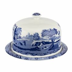 a blue and white cake dish on a platter with an image of a landscape