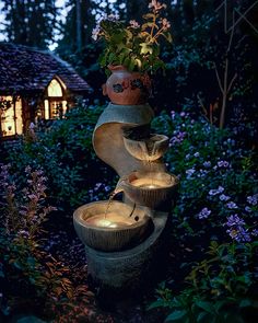 an outdoor fountain in the middle of a garden