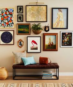 a room filled with lots of framed pictures on the wall next to a brown bench