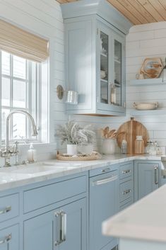 a kitchen with blue cabinets and white counter tops