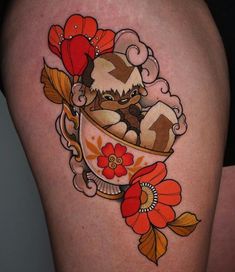 a woman's thigh with an animal in a cup tattoo on it