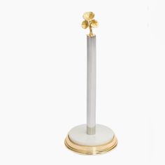 a white and gold pedestal with two flowers on it