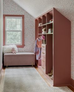 a bedroom with pink walls and white carpeted flooring, built in shelving unit