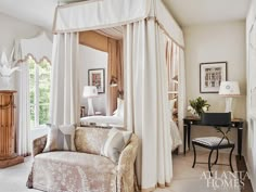 a canopy bed sitting in the middle of a bedroom next to a desk and chair