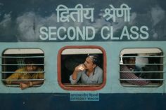 three men are sitting in the window of a blue and white train that reads second class