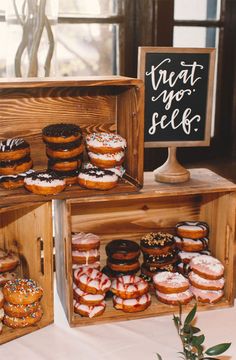 several wooden boxes filled with donuts on top of a table