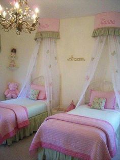 two twin beds with pink and green bedding in a girls'bedroom, one has a chandelier