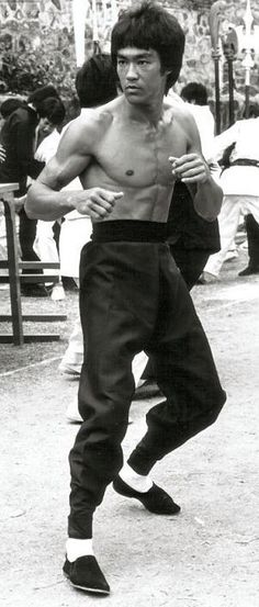 a young man is practicing his moves on the street while others watch from the sidelines