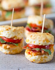 mini sandwiches with bacon, tomato and cheese on them