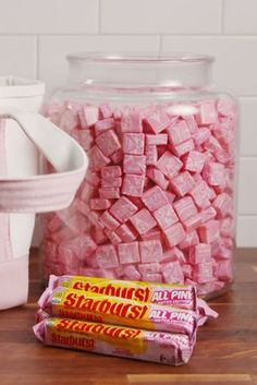 pink marshmallows in a glass jar next to a pair of white shoes