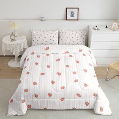 a bed with white sheets and strawberry print on it