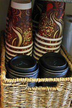 two coffee mugs sitting on top of a wicker basket