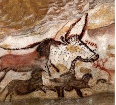 an animal painting on the side of a cave wall with other animals running around it