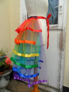 a mannequin wearing a multicolored tulle skirt with red ribbon around the waist