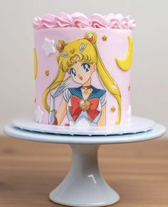 there is a pink cake decorated with sailor moon and stars on the top, as well as an image of princess aurora