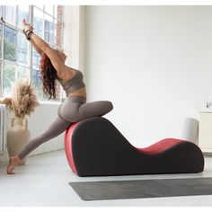 a woman is doing yoga on an exercise mat in front of a window with her legs up