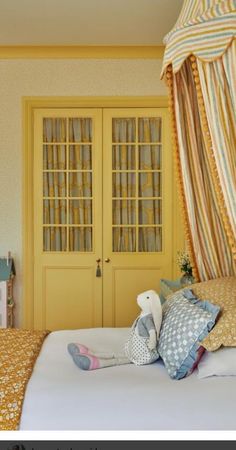 a bed room with a neatly made bed and two doors leading to the bedroom area