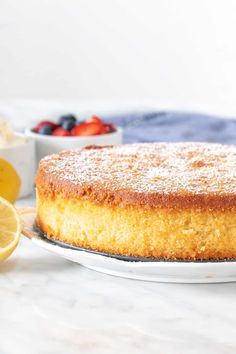 a cake on a plate with lemons and strawberries in the background