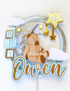 a cake topper with a teddy bear sitting on the moon and stars above it