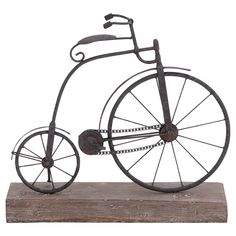 an old fashioned metal bicycle is on a wooden base and has wheels that are attached to the front wheel