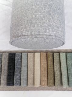 an assortment of different shades of fabric on a white surface with a light fixture in the middle