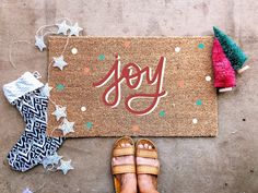 someone is standing in front of a door mat with the word joy on it