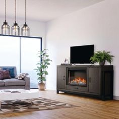 a living room with a couch, coffee table and fire place in front of a large window