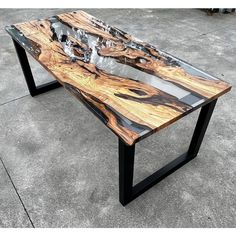 a table made out of wood and metal legs on concrete flooring with cement area in the background