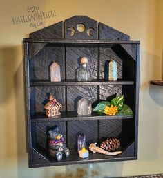 a shelf filled with lots of different items on top of a table next to a wall