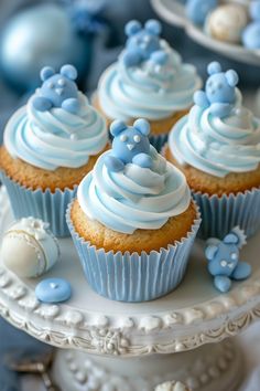 cupcakes with frosting and blue decorations on a cake plate