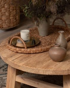 a wooden table with two vases and a basket on it's end shelf